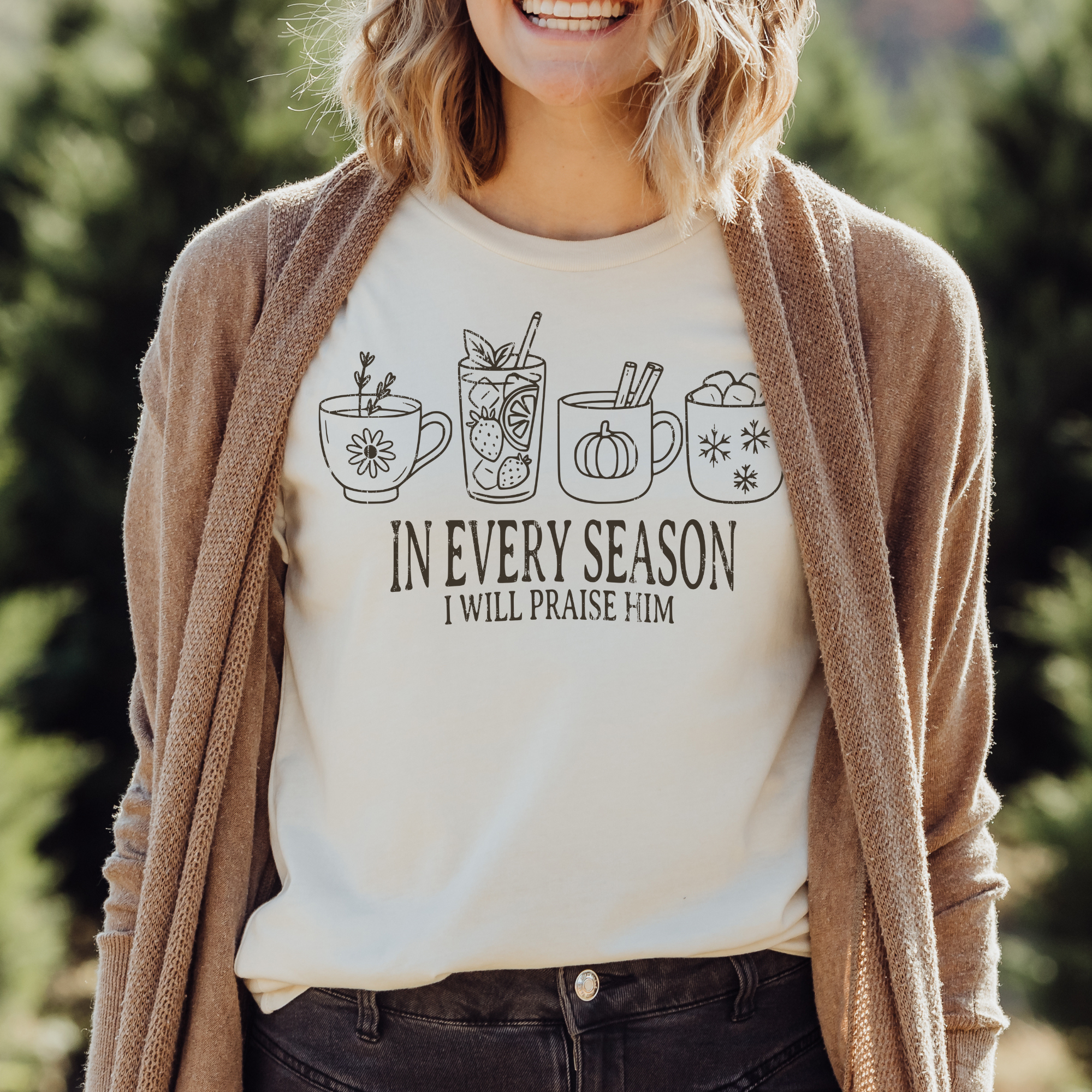 Person wearing a shirt with coffee cup illustrations and text, standing outdoors.